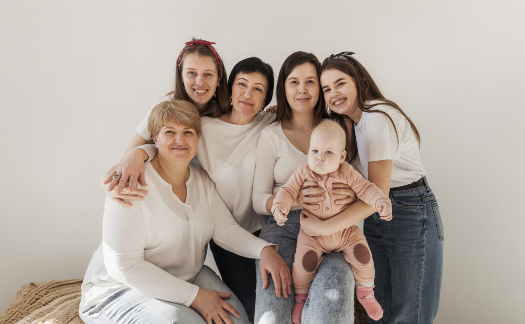 Women In White Shirts Posing Together And Baby
